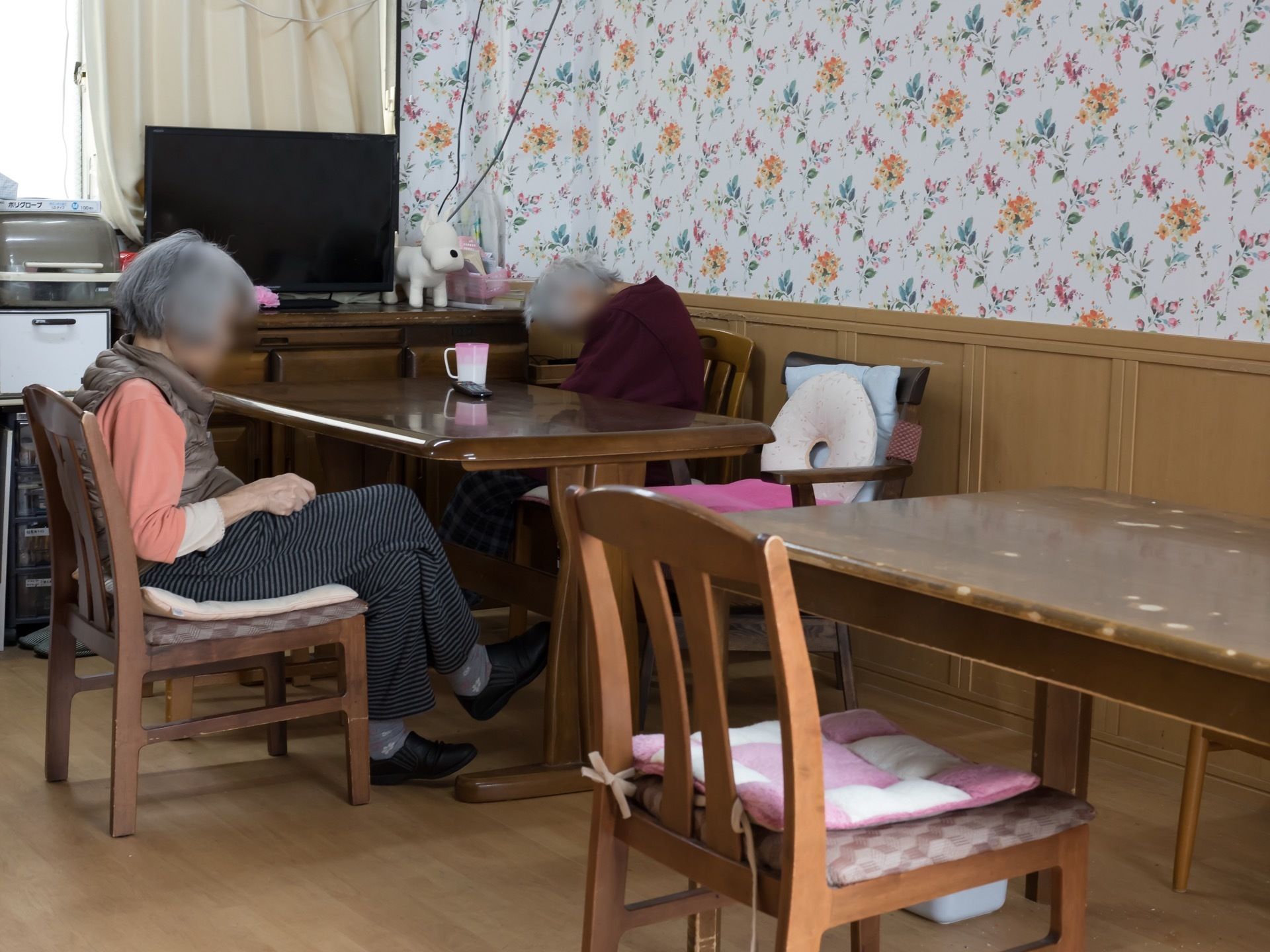 部屋の奥の方には、木製のキャビネットや、食器入れ、収納ボックスなどが置かれている。キャビネットの上には、テレビが設置されている。
