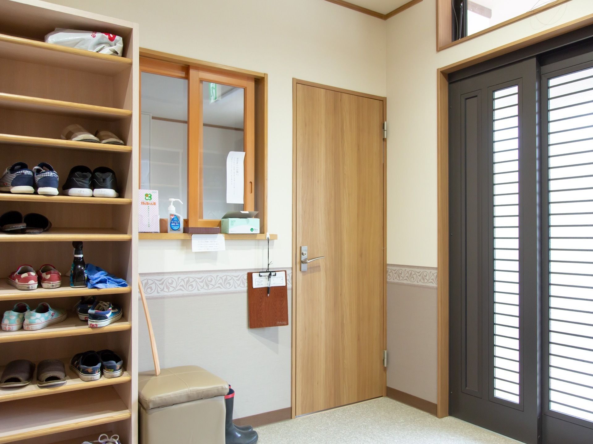 玄関を入ってすぐに、受付の小窓がある。下駄箱の前には、正方形のシートの椅子と靴べらが用意されている。
