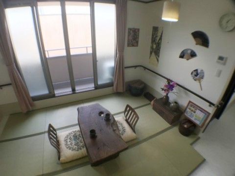 畳コーナーが設けられている。テーブルや座椅子が置かれ、壁には扇子やうちわなどがインテリアとして飾られている。