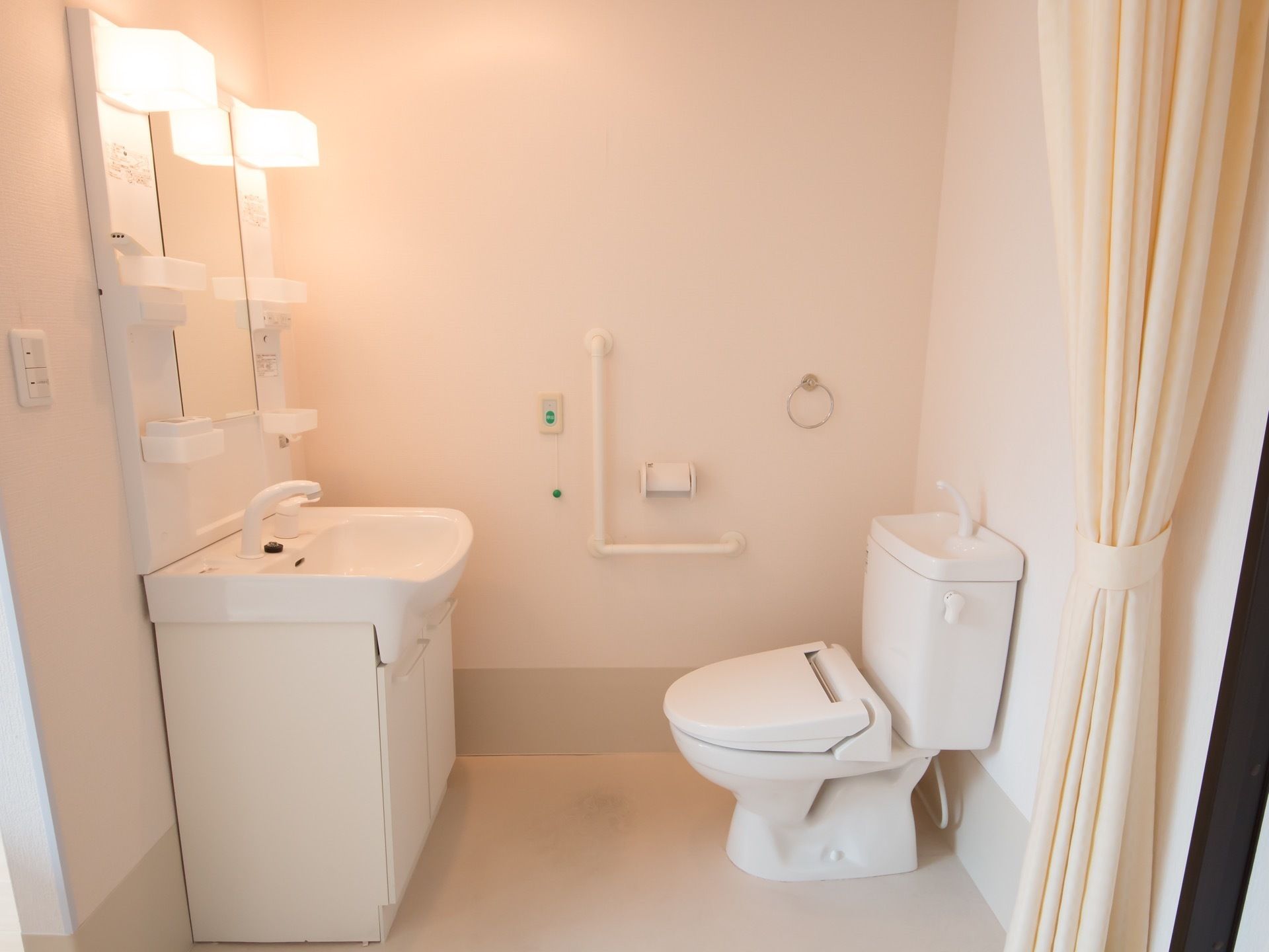 便座前に洗面化粧台があり、照明が2つついている。トイレスペースはカーテンで仕切ることにより、楽に出入りできる仕組みである。
