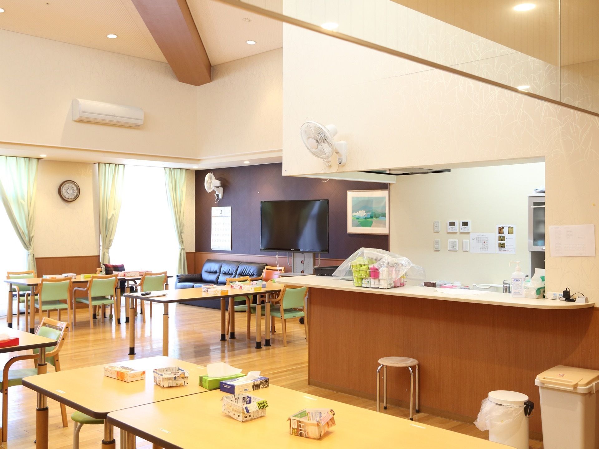 食堂にテーブルと椅子が並べられている。リビングとキッチンが併設されている。仕切りがなく、開放感がある。