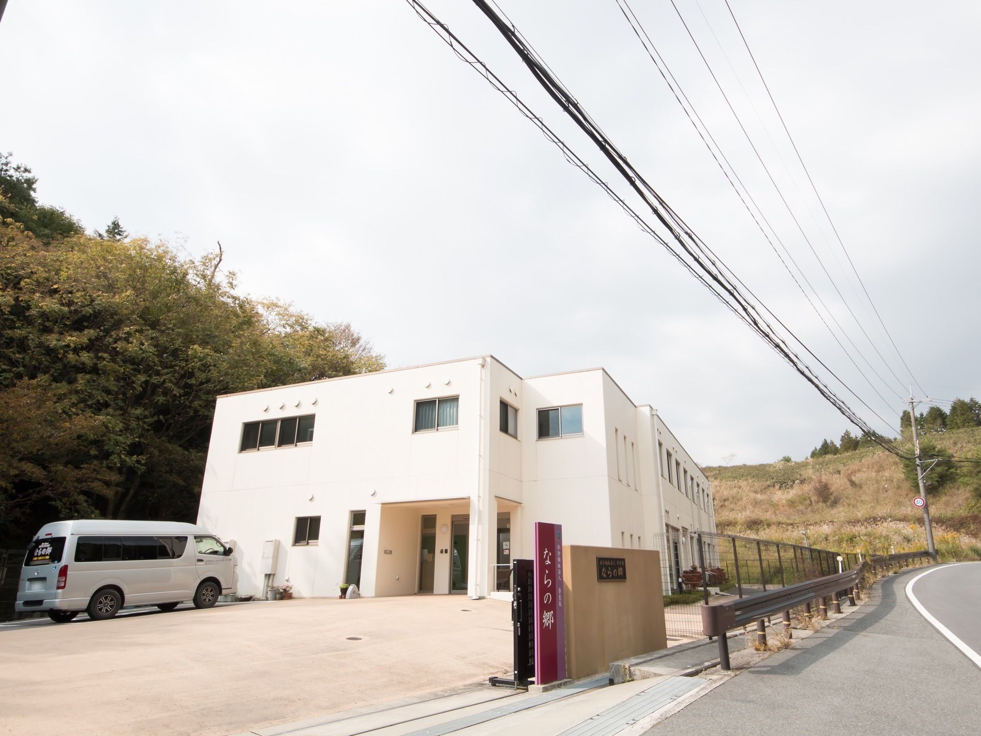 建物前に広い駐車スペースを設けた２階建て施設である。敷地に沿ってフェンスが設置されており、周囲は豊かな自然に囲まれている。