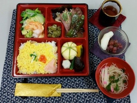 テーブルの上に、ランチョンマットが敷かれ、ちらしずしの幕の内弁当とおすましやデザートがお茶と共に提供されている。