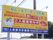 施設のご入居者様を募集する、黄色い看板が設置されている。簡単な施設の説明と、問い合わせ先の電話番号なども記載されている。