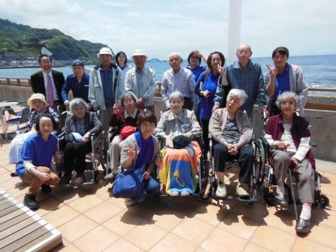 海の見える場所で記念撮影をする高齢者