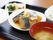 この日の食事が食器に盛り付けられて黒色のお盆の上に用意されている。メイン料理は魚と大根の煮物である。