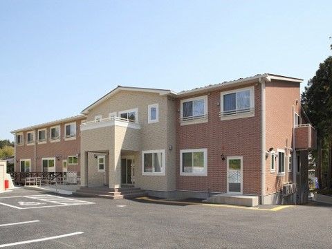 ブラウンとベージュの２色のレンガ造りの２階建て施設外観