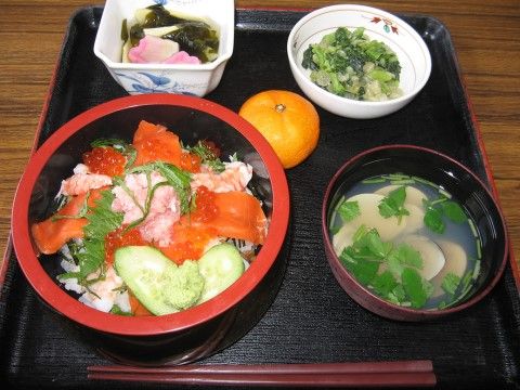 海鮮丼の他、お吸い物、2種類の小鉢、みかんの載ったお膳