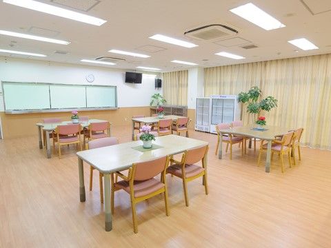 床や壁の１部分に木を用いた温かみのある空間である。４人掛けの机がいくつも置いてある。ほぼ１面が窓になっている。
