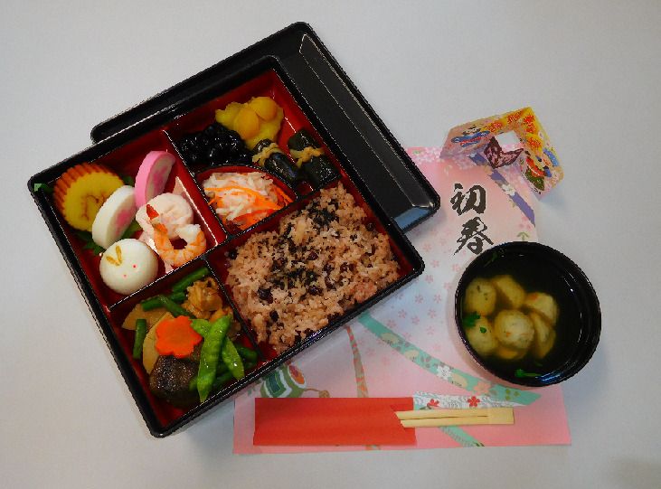 重箱に入ったおせち料理と吸い物のセット