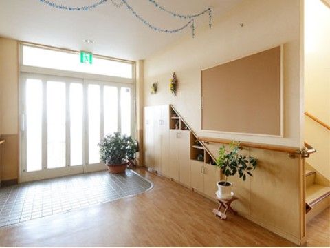 広々としたエントランスはバリアフリーとなっている。玄関から明るい日差しが入り、観葉植物が置かれている。