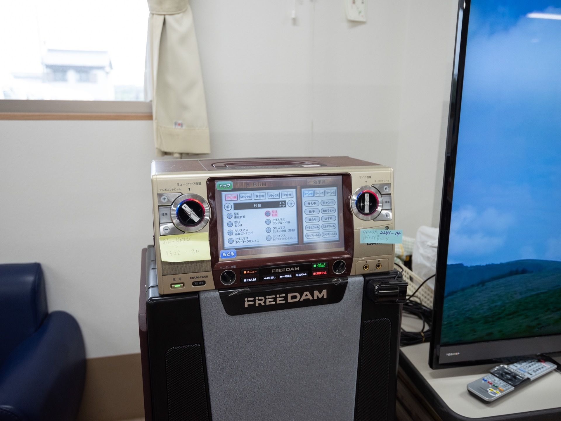 入居者様が自由に過ごす共有スペースに、カラオケ機器が設置されている。となりには、大きなテレビが置かれている。