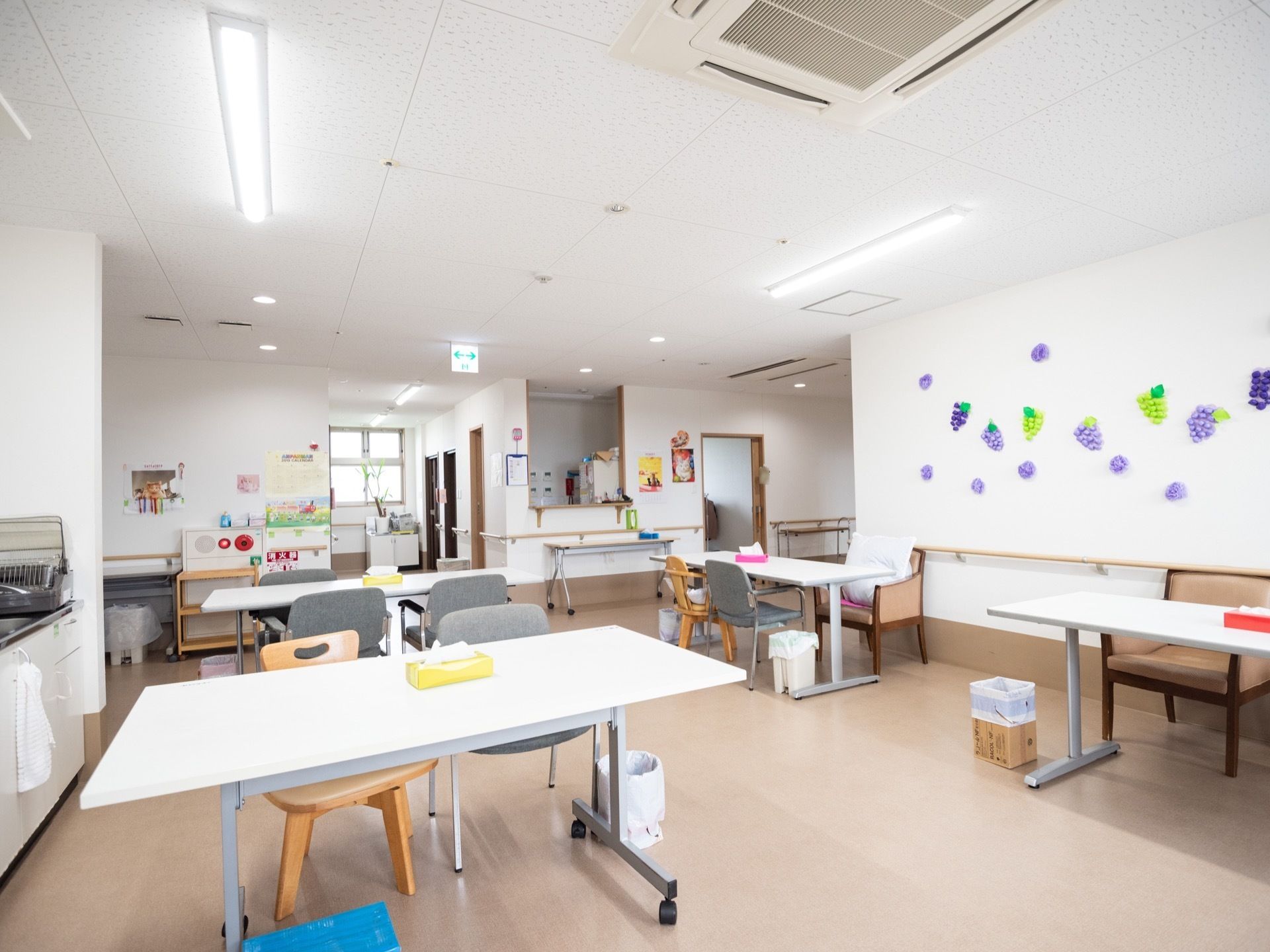 白色を基調とした、明るい雰囲気の共有スペースである。壁に入居者様が制作した、果物の作品が飾られている。