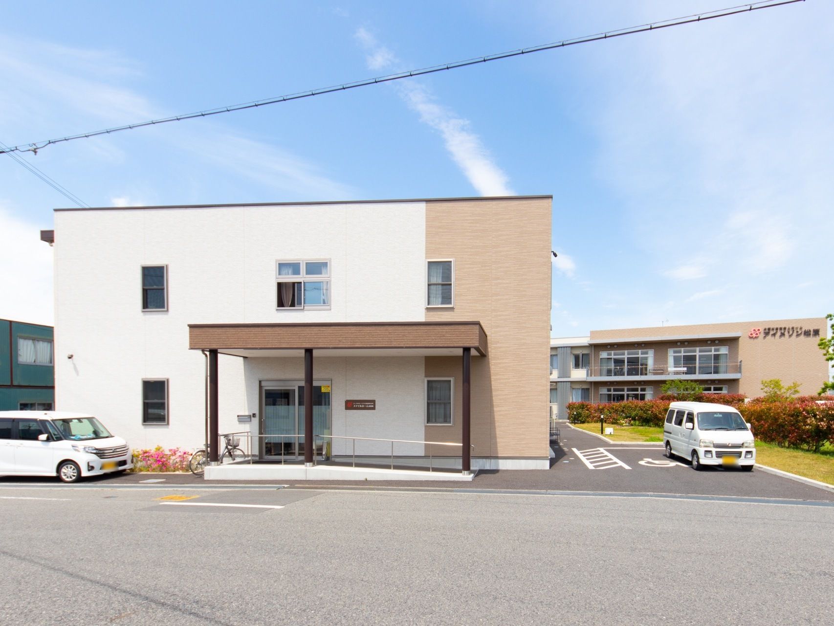 四角くシンプルでスタイリッシュな建物。玄関まではスロープになっており、車椅子での出入りもストレスなく行うことが可能。