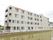 4階建ての鉄筋コンクリートでできた建物は田んぼの横に建っている。大きな施設名が壁にオレンジの文字で書いてある。