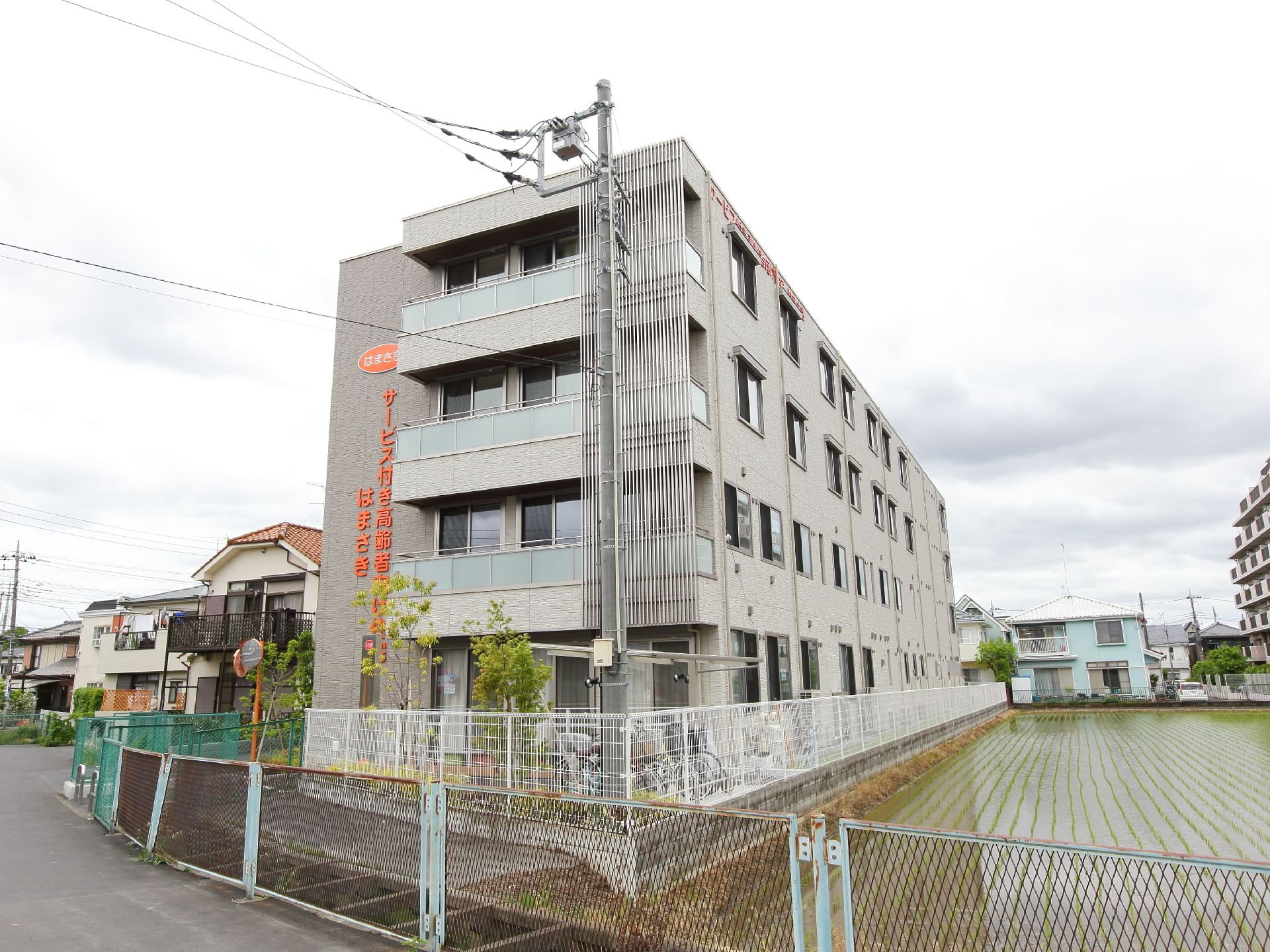 建物は住宅街の中にあり、鉄筋コンクリート造りの4階建てとなっている。大きな施設の名前がわかりやすい。