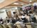 壁の前でバンド演奏が行われている。椅子に座った10人を越す入居者様達が、ボーカリストの合図に従い、歌詞カードを見ながら一緒に歌っている。