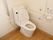 洋式トイレの周りにはL字型の手すりや可動式のひじ掛けが追加されている。壁にはナースコールも設置されている。