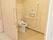 居室のトイレは入り口の横に設置されて扉は横開き。便器は水洗トイレで壁には手すりと呼び出しスイッチがが設置されている。