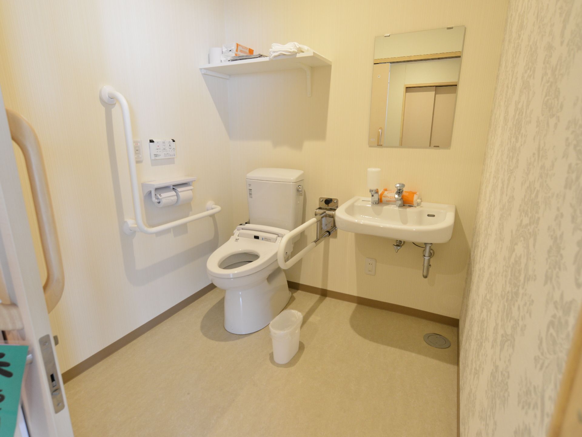 施設には共同で使用できるトイレも設置されている。水洗トイレと手すり、洗面台と鏡も中に設置されている。備品類も置かれている。