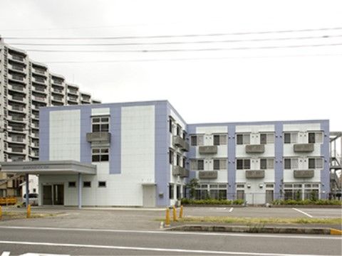 専用の駐車場が用意されている、三階建ての建物の外観