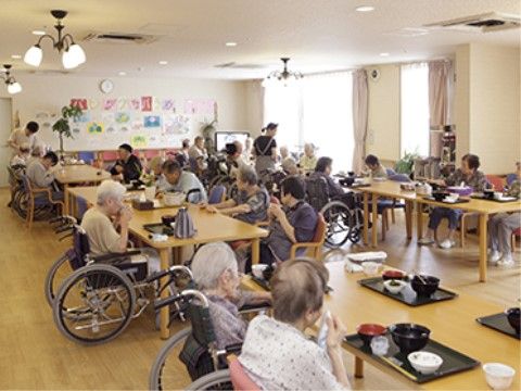 広々としたリビングルームで、利用者さんがお食事を召し上がっている様子