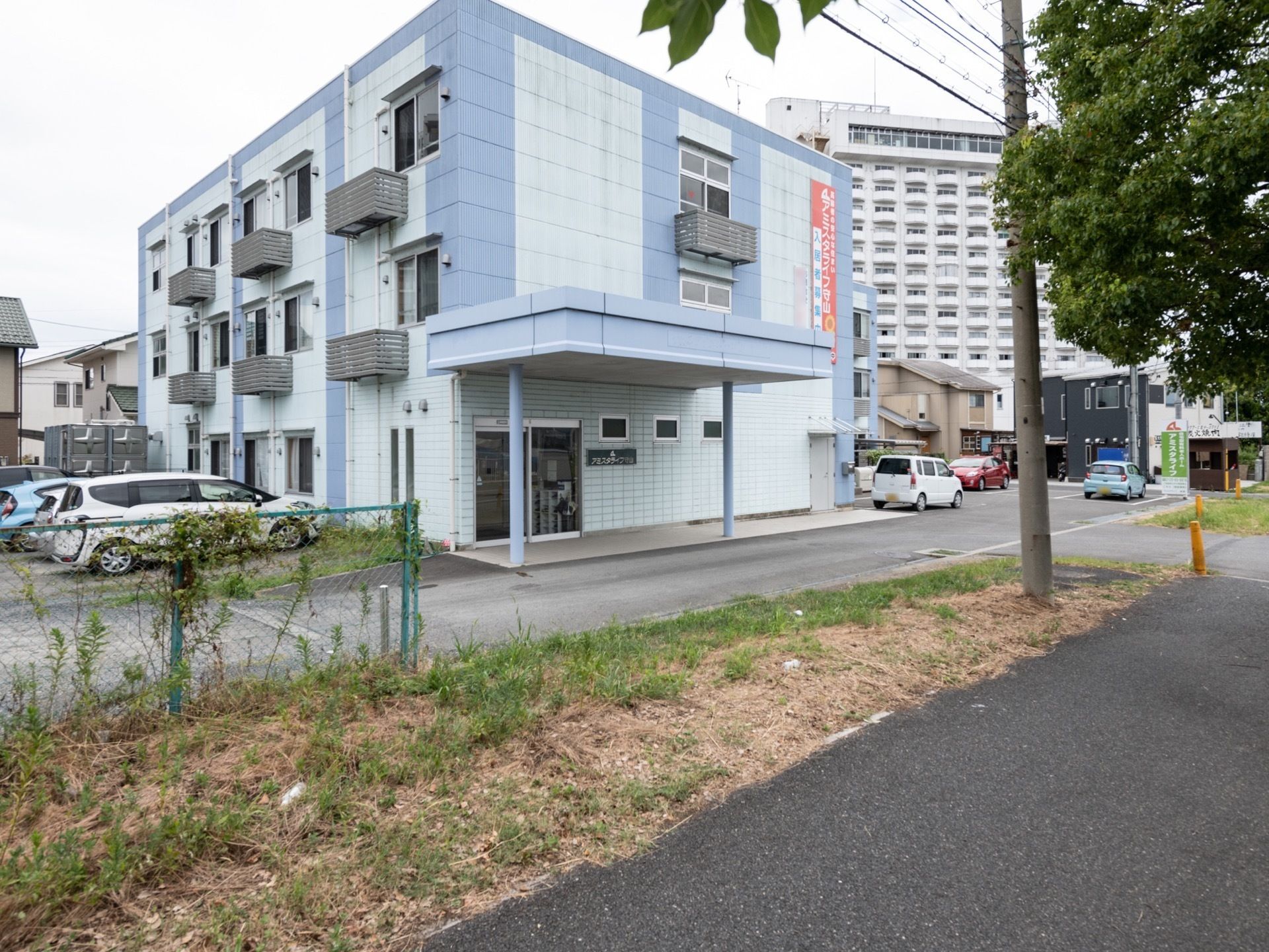 ブルーを基調とした3階建ての建物である。周辺には住宅が広がっている。施設名の看板があり、遠くからでも分かりやすい。