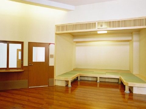 エントランスの一角に設けられた談話スペース。正座が難しい入居者様が腰掛けて話せるよう、畳敷きの縁側風にベンチが組まれている。