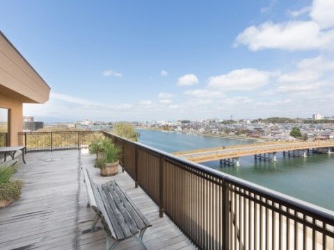 オープンテラスでは、自然豊かな川辺の景色を眼下に一望できる。広いウッドデッキを囲うフェンスは、視界を遮らない半透明のものが使用されている。