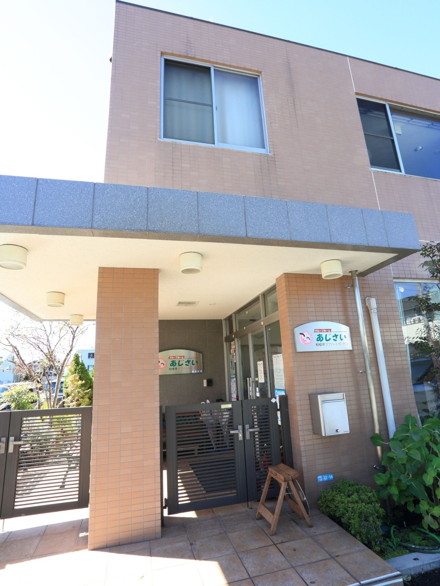 レンガ風の茶色を中心とした建物になっている。玄関口には温かみのあるロゴがあしらわれた看板が設置されている。