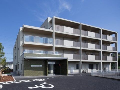 専用の駐車場があり、都会的なデザインの四階建ての建物の外観