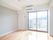 窓が大きく明るい部屋で、ベランダからは遠くの自然を楽しめる。エアコンが取り付けられており、快適に過ごすことができる。