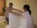 一室で、女性の入居者様と女性スタッフが向き合い、にこやかに会話しながら、白いシーツをたたんでいっている。