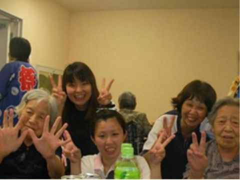 スタッフの隣でピースサインを作ったり、両手を上げたりしている入居者たち