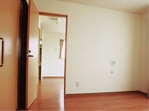 居室はフローリングで、いつくかの部屋に分かれている。窓にはカーテンがかけられている。壁には呼び出しボタンが設置されている。