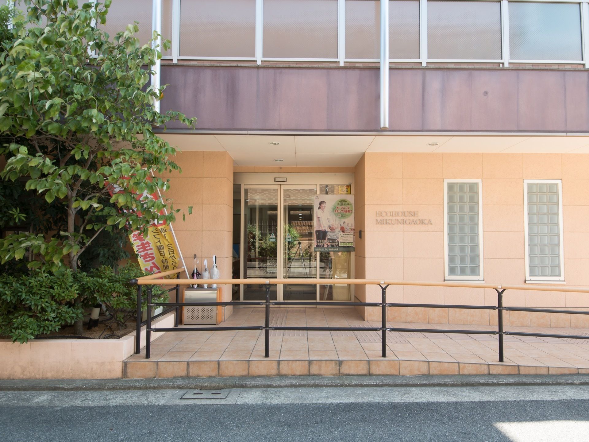 玄関は淡いプラウンのタイル張りとなっている。入口の横の壁には細長い形の窓が２つ並んで設置されている。