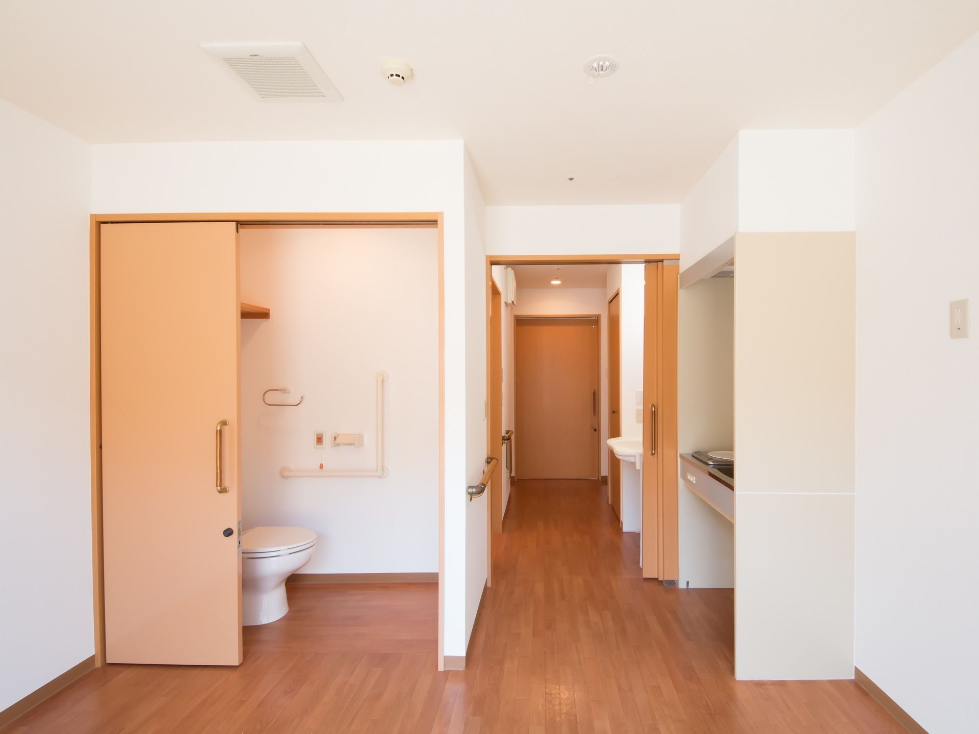 室内はフローリング張りでナチュラルな雰囲気である。トイレへのドアは大きく開くスライド式のドアとなっている。