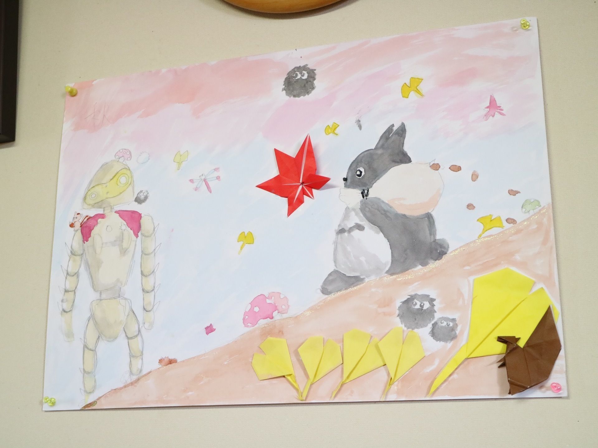 薄いベージュの壁に、アニメのキャラクターのイラストが貼られている。大きな画用紙に水彩絵の具で描かれている。