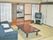 和室の真ん中に座卓が置かれ、その前にソファーが並べてある。部屋の隅にテレビがあり、廊下を隔てて奥にキッチンがある。
