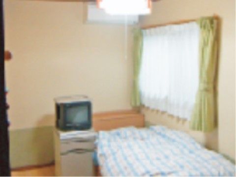 部屋の天井には蛍光灯が付けられ、窓のカーテンは2重になっている。ベッドが1台置いてあり、その頭上にエアコンが設置されている。