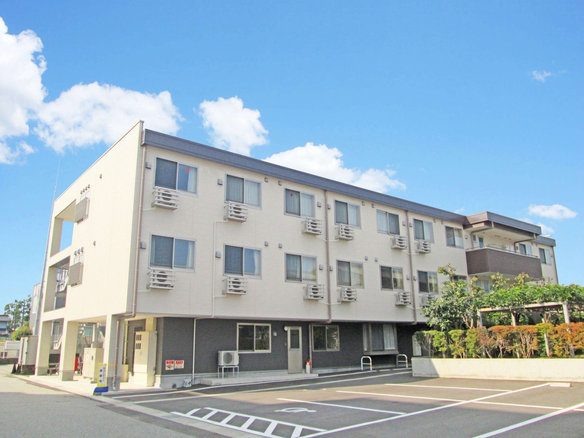 落ち着いたホワイトとグレー調に施された3階建ての建物