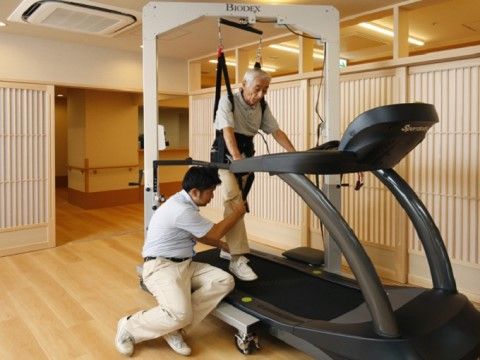 トレーニングルームで歩行訓練をおこなう入居者の男性