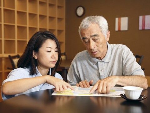 リビングルームで男性の入居者に寄り添う女性スタッフ