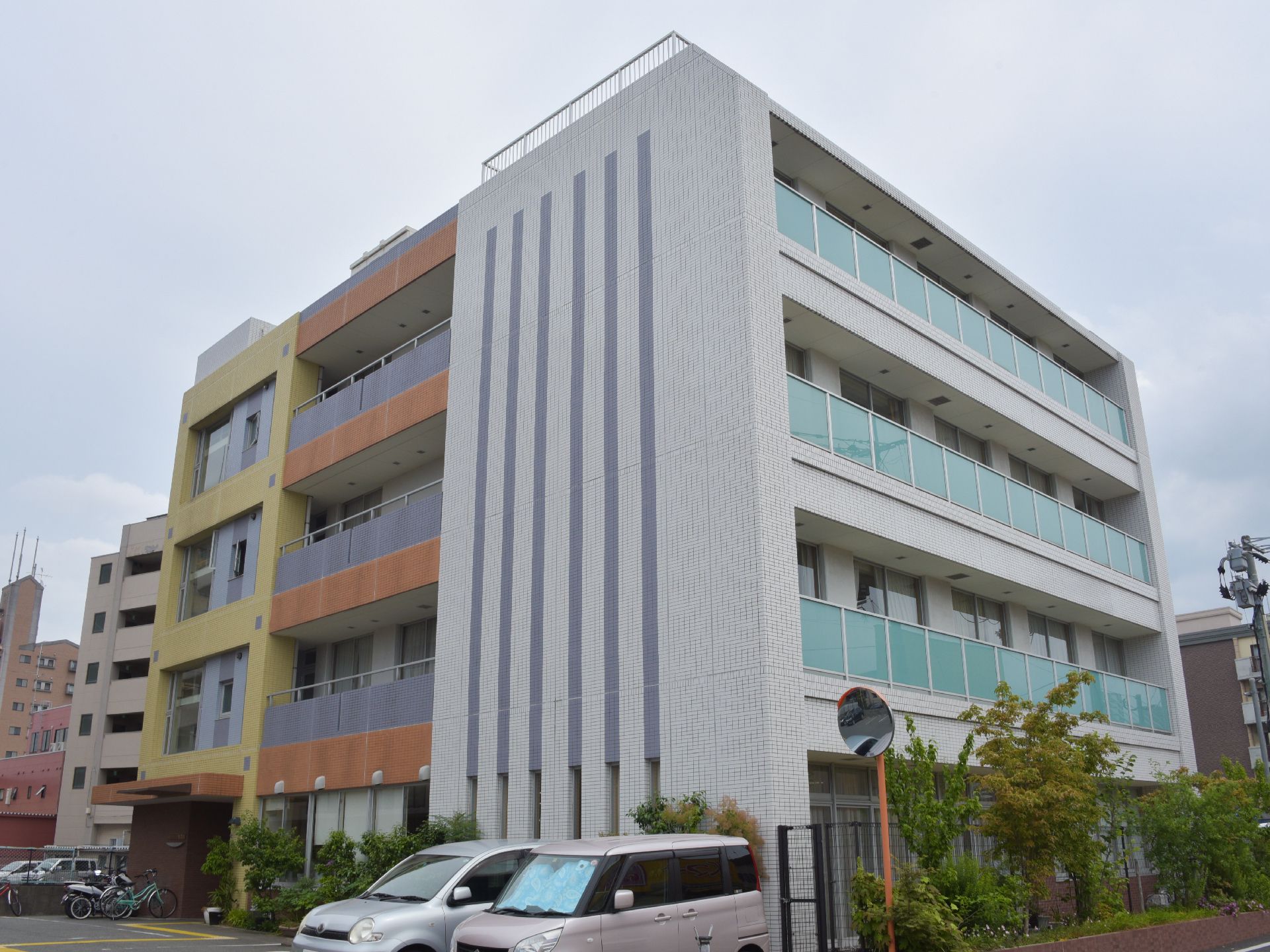 外観は、淡い黄色を基調にしたデザインである。隣接している建物は、デイケアセンターや内科なので、受診するのも便利。