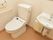 バリアフリー仕様のライトブラウンの床が落ち着いた雰囲気のトイレ洗面スペースである。車いすでも使いやすい造りになっている。