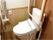 トイレの便器には、はね上げ式のアームレストが設置されている。壁には、手すりや呼び出しボタンが取り付けられている。