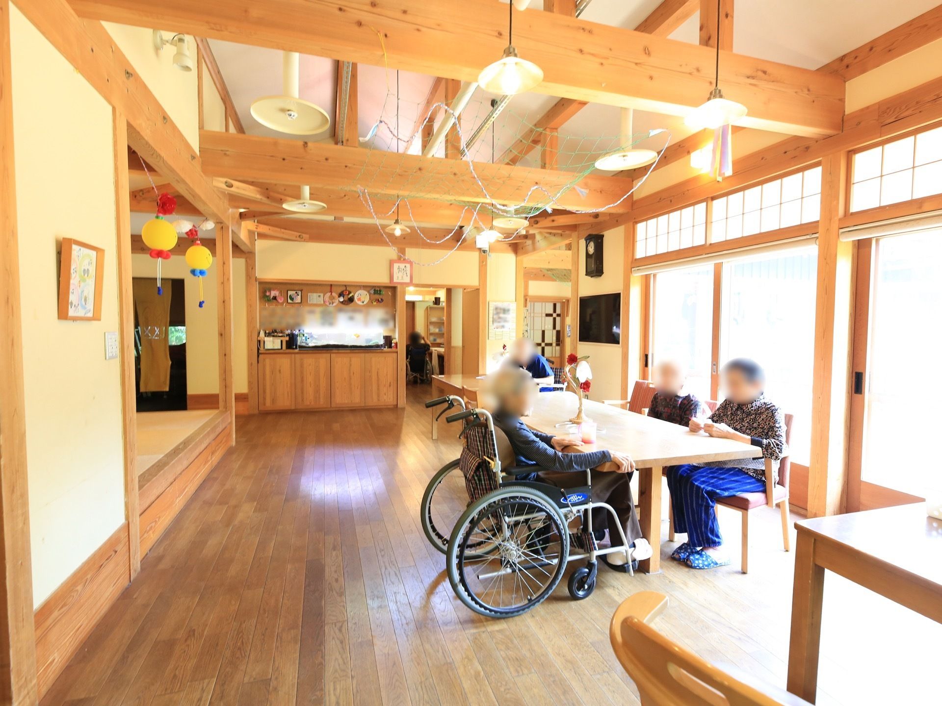 天井は吹き抜けとなっており、複数の照明がかかっている。フロア中央には、木製のダイニングテーブルが配置されている。
