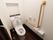 トイレは洋式で、壁には手すりや緊急時呼び出しブザーが備わっている。便器の背部の壁には、収納棚がある。