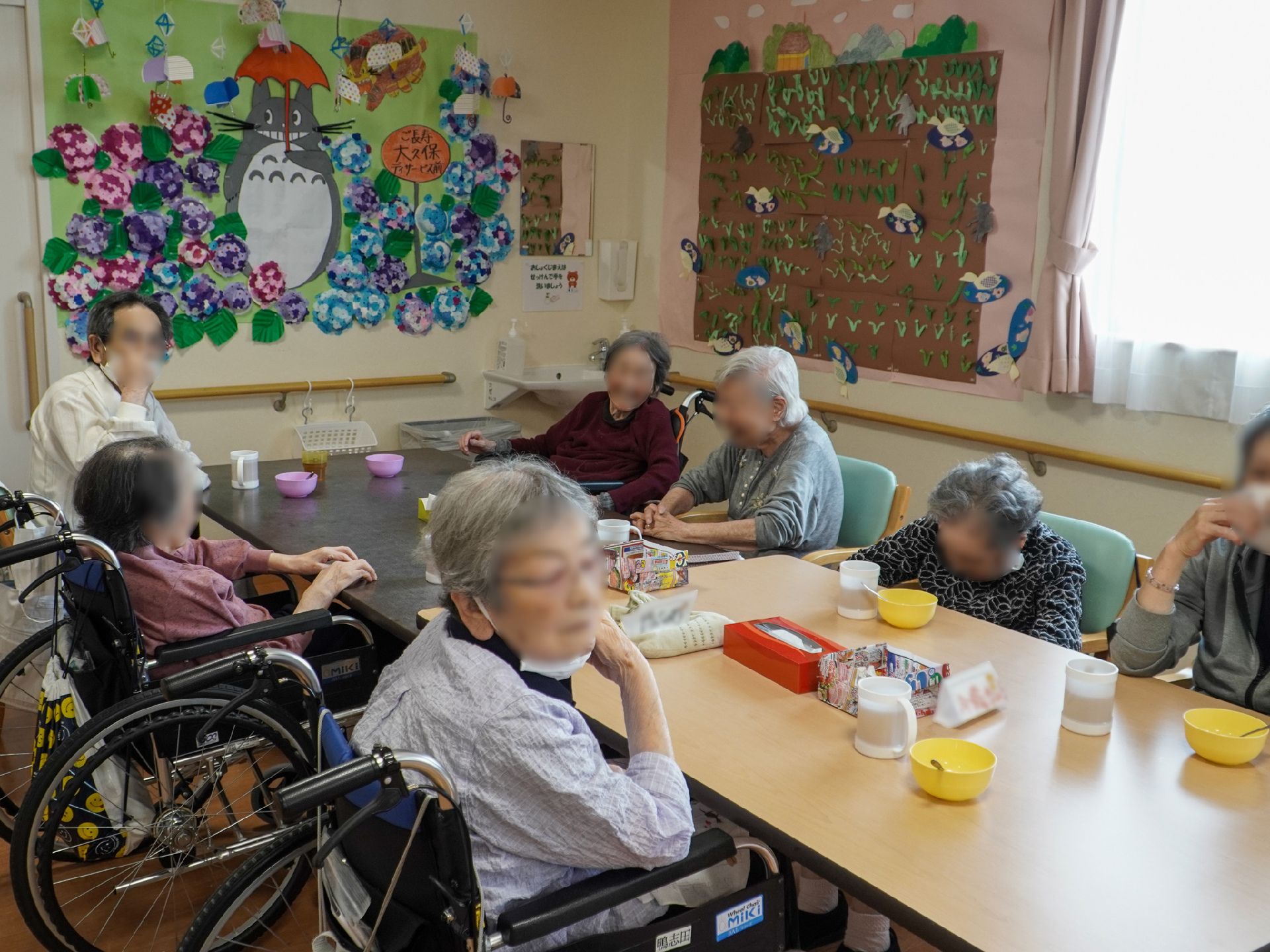 木製の机の周りに集まる入居者様