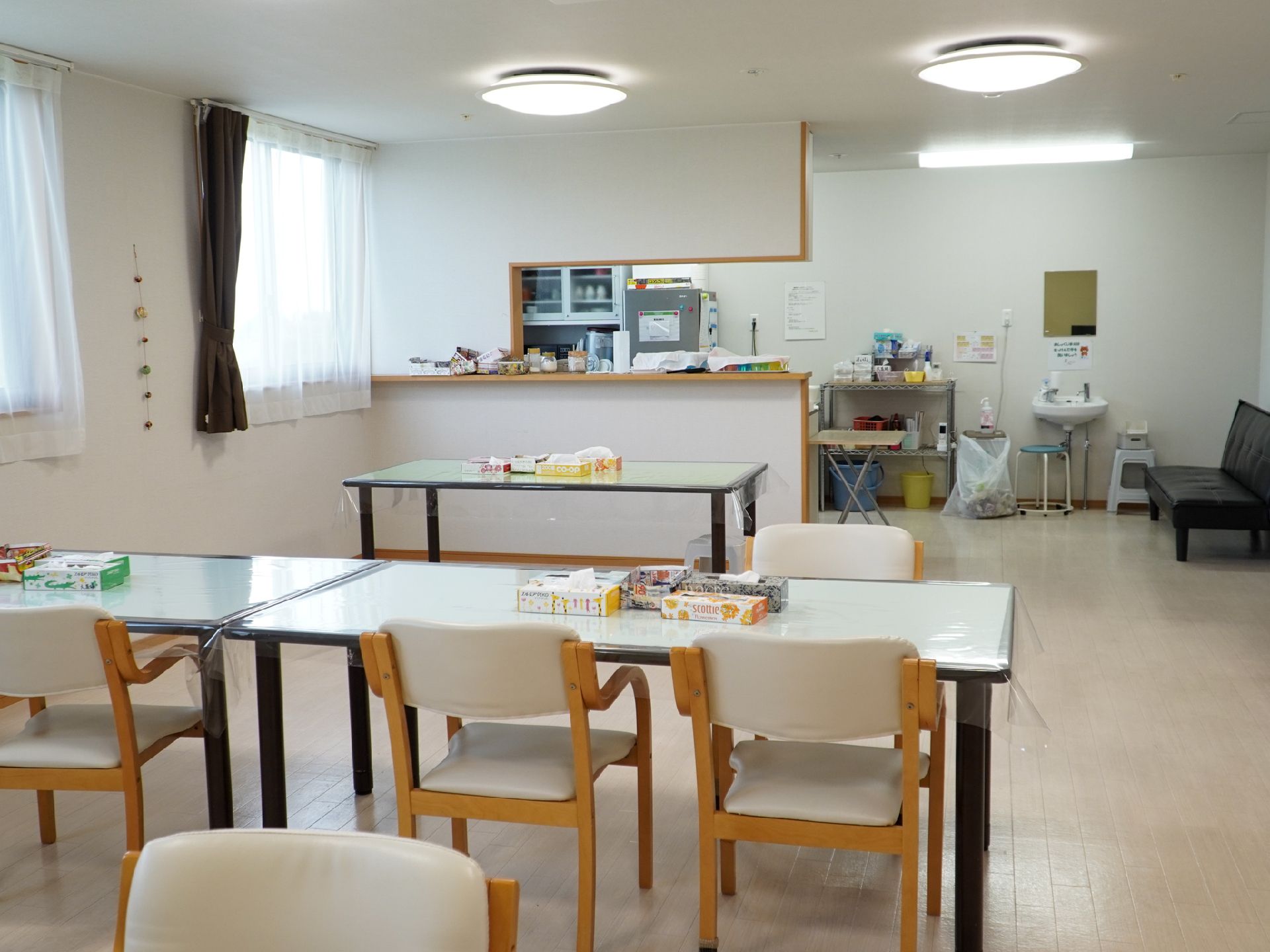 机と椅子が並んでいる白い壁の広間